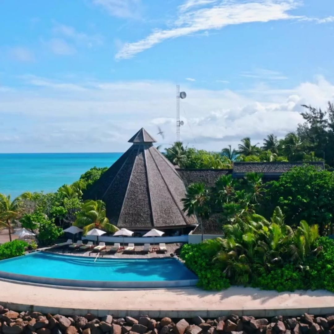 Luxury tropical resort with infinity pool overlooking the ocean, a popular charter destination.